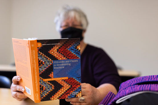 Student reading a book in a social work class at the University of Michigan-Flint.