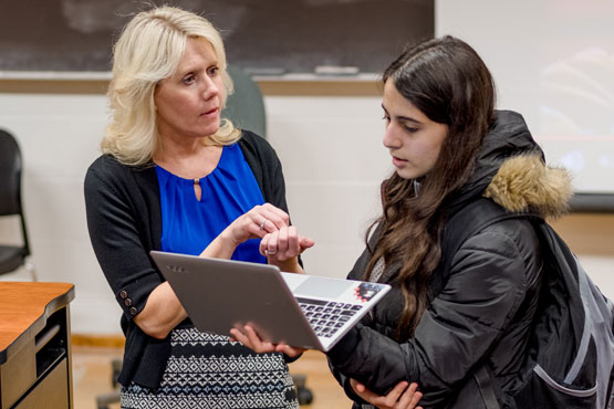 Faculty member helping a student during a psychology class.
