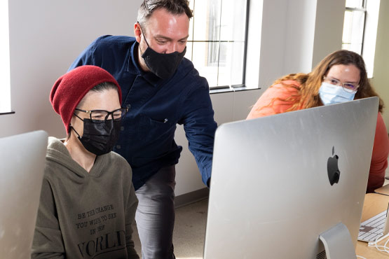 Two students working faculty in a design class at the University of Michigan-Flint.