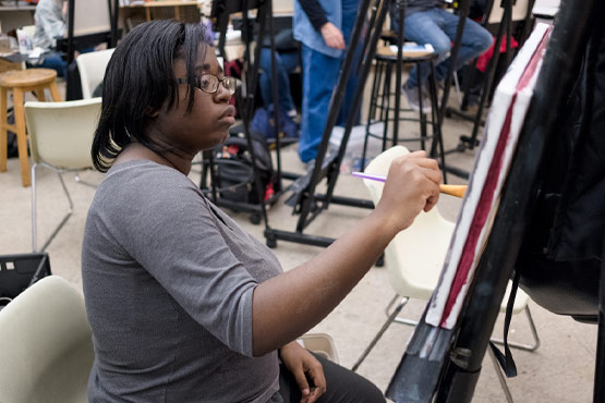 Student painting at the University of Michigan-Flint.