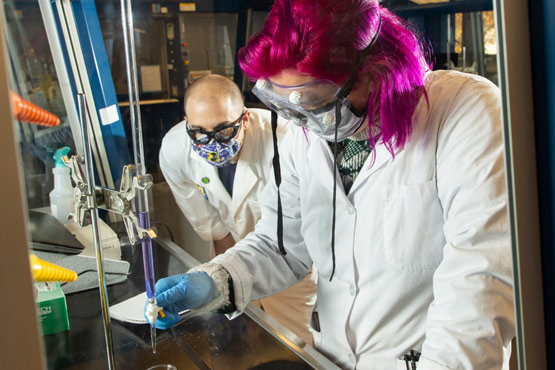 Estudiante y miembro de la facultad investigando en un laboratorio de química en la Universidad de Michigan-Flint.