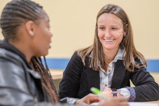 Communication faculty member talking with a student at the University of Michigan-Flint.