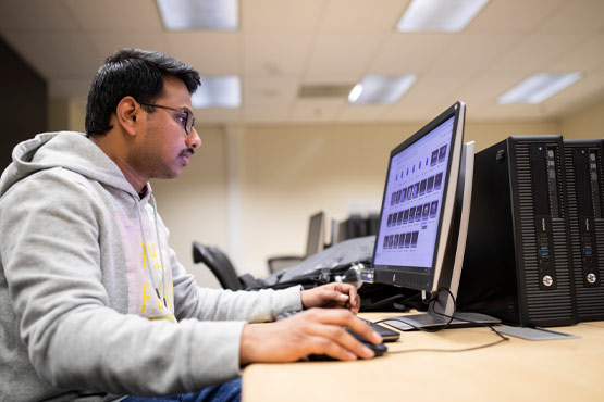 University of Michigan-Flint mechanical engineering student working on a computer.