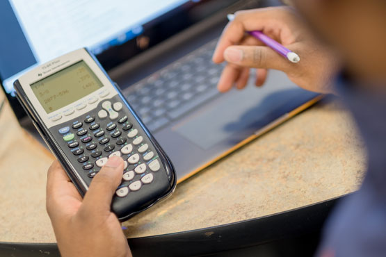 Estudiante usando una calculadora.