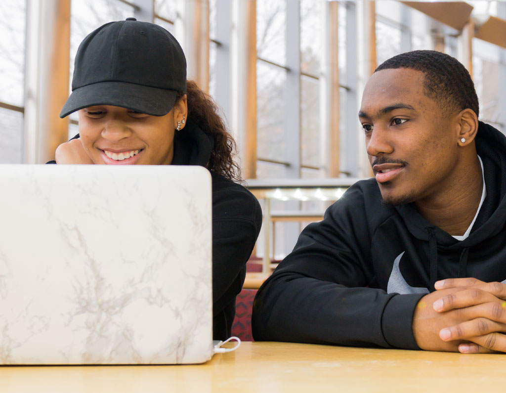 Two students working on a laptop.