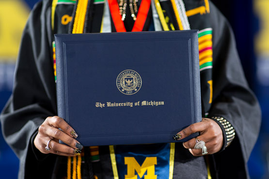 Graduate holding diploma cover.
